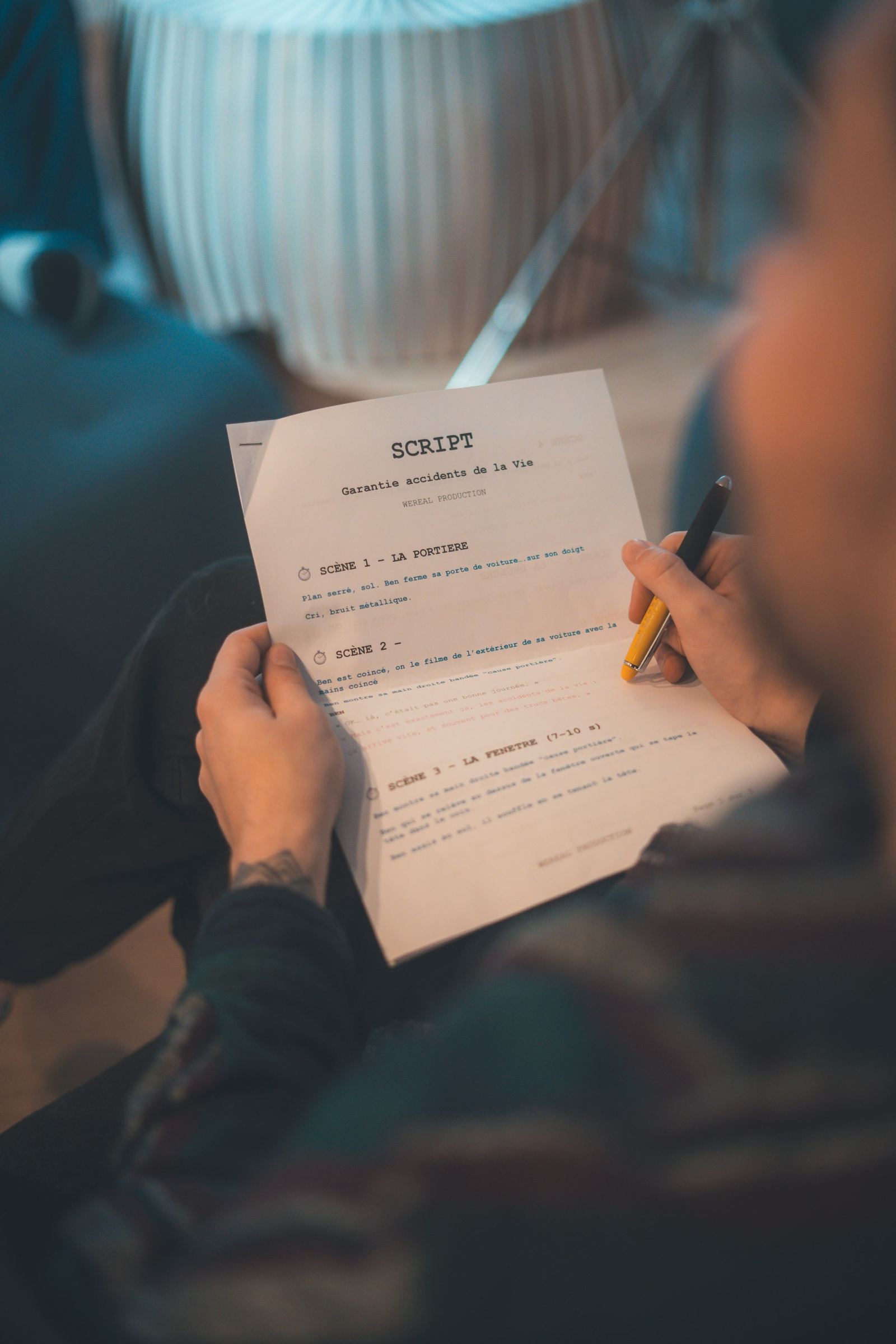 A person marking a printed screenplay with a pen. Editorial photograph, not a Quilty report.